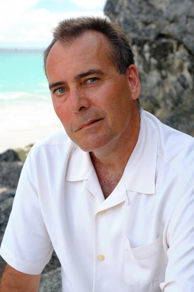 Headshot of Bob Cancalosi sitting on a beach